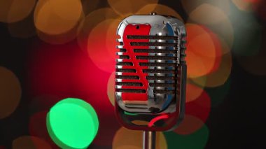 Karanlık arka planda, yanıp sönen ışıkları olan klasik bir mikrofon, yakın plan. Bokeh etkisi