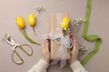 Çiçek kutusu, çiçek, makas ve bej arka planda kurdele olan bir çiçekçi.