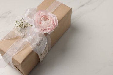 Çiçekçi. Üzerinde çiçekler ve kurdele olan bir kutu beyaz mermer masa, yakın plan. Metin için boşluk