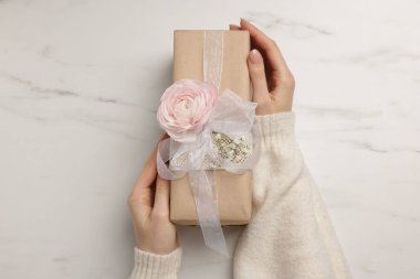 Beyaz arka planda hediye kutusu olan bir çiçekçi.