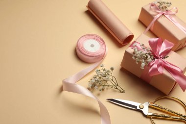 Çiçekçi. Bej arkaplanda kutular, çiçekler, kurdele ve makas, metin için boşluk