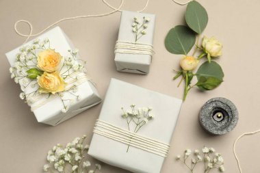 Çiçekçi. Kutular, çiçekler ve yanan mum açık gri arka planda, düz yatıyordu