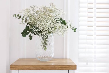 Evdeki masadaki vazoda güzel çikila çiçekleri ve okaliptüs dalları. Metin için boşluk