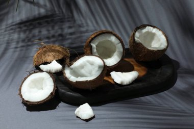 Gri arka planda tropikal palmiyelerin taze hindistan cevizleri ve gölgesi, yakın plan