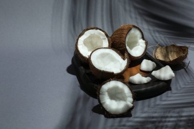 Gri arka planda tropikal palmiyelerin taze hindistan cevizleri ve gölgesi, yakın plan. Metin için boşluk