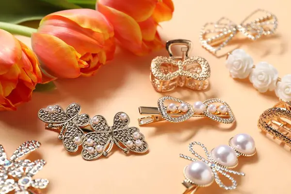 Bej arka planda güzel saç tokaları ve laleler, yakın plan.