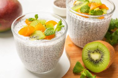 Kivili lezzetli chia pudingi, beyaz masada şeftali ve nane şekeri, yakın plan.