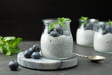 Yaban mersinli Chia pudingi ve gri desenli masada nane şekeri.