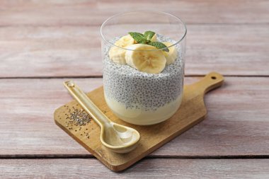 Ahşap masada servis edilen, muzlu ve nane şekerli lezzetli chia pudingi.