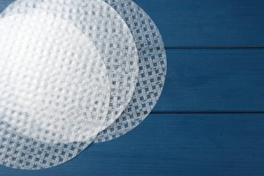 Mavi ahşap masadaki yenilebilir pirinç kağıtları, düz yatıyordu. Metin için boşluk