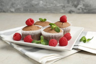 Ahududu ve nane aromalı lezzetli çörekler. Gri desenli masa, yakın plan.