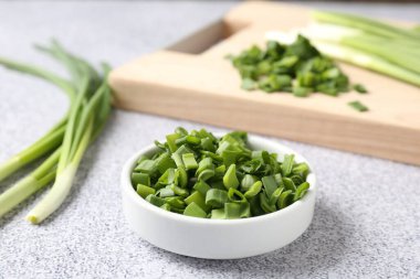 Açık gri masada taze taze soğan var. Yakın plan.