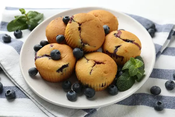 Yaban mersinli lezzetli kekler ve beyaz masada nane şekeri, yakın plan.