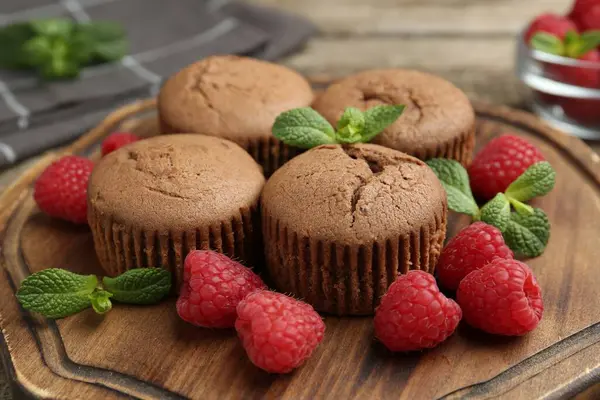 Ahududulu lezzetli kekler ve ahşap masada nane şekeri, yakın plan.