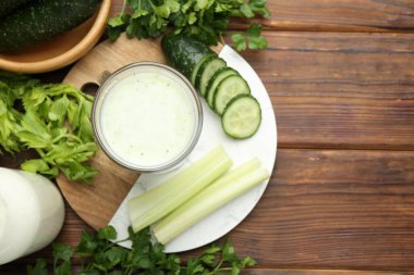 Sağlıklı maydanoz içeceği, yapraklar, kereviz ve salatalık ahşap masada, düz yerde. Metin için boşluk