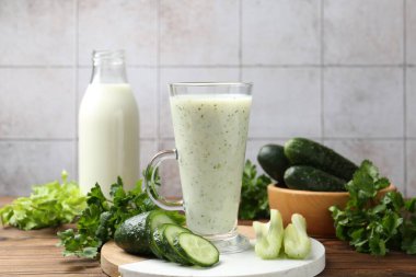 Sağlıklı maydanoz içeceği, yapraklar, kereviz ve salatalık ahşap masada, yakın plan.