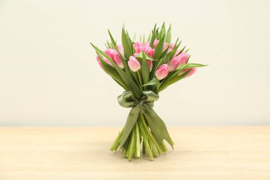 Ahşap masada açık gri arka planda güzel laleler.