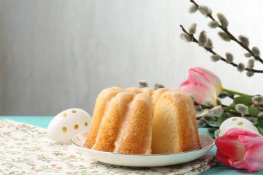 Lezzetli kek, Paskalya yumurtası, söğüt dalları ve masada laleler.