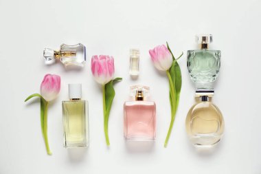 Aromatik parfüm şişeleri ve beyaz arka planda güzel laleler.