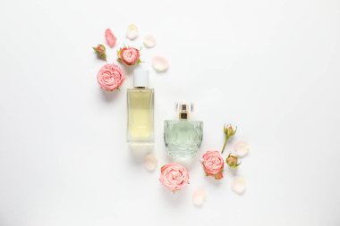 Düz kompozisyon, beyaz arka planda aromatik parfüm şişeleri ve güzel çiçekler vardı.