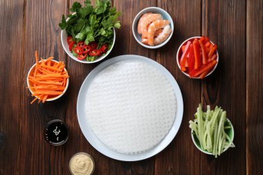 Yenebilir pirinç kağıtları ve malzemeler ahşap masada, düz yerde.