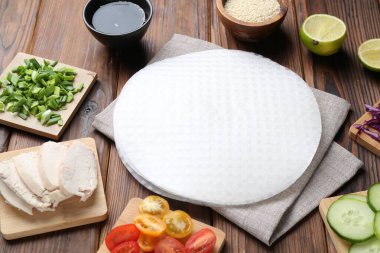 Yenilebilir pirinç kağıtları ve malzemeler ahşap masada, yakın plan.