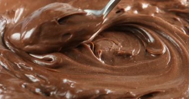 Lezzetli çikolatalı pudingi kaşıkla yaymak, yakın çekim.