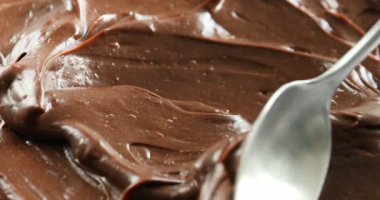 Lezzetli çikolatalı pudingi kaşıkla yaymak, yakın çekim.