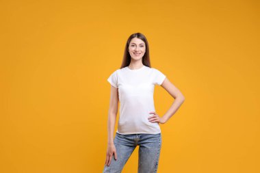 Turuncu arka planda beyaz tişört giyen bir kadın. Tasarım için model