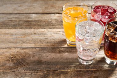 Farklı aromalı soda. Bardaklar ahşap masada buzlu. Yakın plan. Metin için boşluk