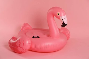 Pembe arka planda şişirilebilir flamingo şekilli halka