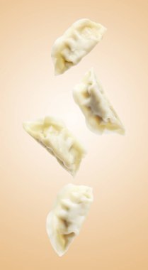 Bej arkaplana dökülen lezzetli haşlanmış gyoza (hamur tatlısı)