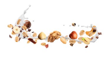 Yulaf gevreği, fındık, çikolata kırıntıları ve beyaz arka planda havaya süt sıçratma. Pankart tasarımı