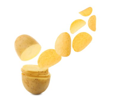 Çiğ patates dilimleri beyaz arka planda havada gevrek cipslere dönüşüyor.