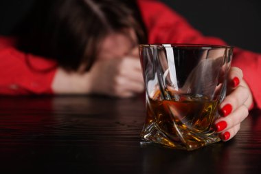 Alkol bağımlılığı. Masasında viski olan zavallı kadın. Karanlık, seçici bir odak noktası.