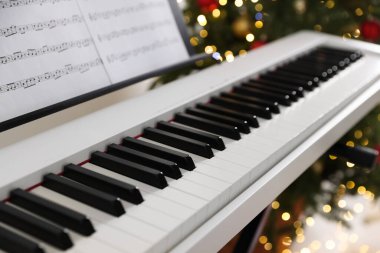 Bulanık Noel ışıklarına karşı müzik kağıtlarıyla sentezleyici, yakın plan. Bokeh etkisi