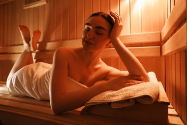 Saunada bankta uzanmış güzel bir kadın