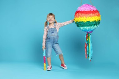 Parlak pinyatalı ve açık mavi arka planda mutlu bir kız.