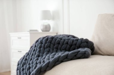 Odadaki kanepede örülmüş merino yün ekose.