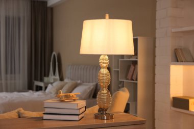 Güzel gece lambası, kitap yığını ve yatak odasındaki çekmecelerin üstündeki uçak modeli.