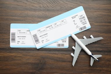 Seyahat acentesi. Uçuş biletleri ve uçak modeli tahta masada, düz yatıyordu.