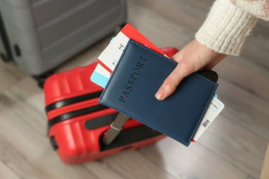 Pasaportlu kadın, biletler ve bavullar içeride, yakın plan.