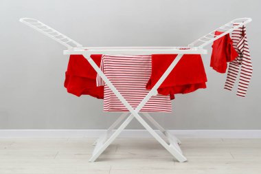 Gri duvarın yanında temiz çamaşırları olan kuru askı.