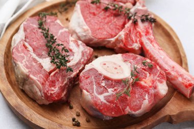 Açık gri masada çiğ et ve baharat parçaları, yakın plan.