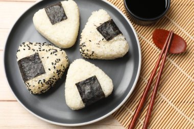 Pirinç topları (onigiri), soya sosu ve ahşap masa üzerindeki çubuklar, düz yatak. Geleneksel Japon yemeği