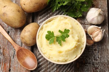 Maydanozlu patates püresi, ahşap masada sarımsak ve kaşık.