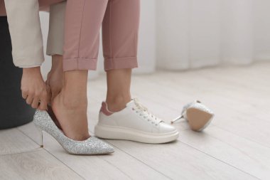 Evde ayakkabılarını değiştiren bir kadın, yakın çekim. Metin için boşluk