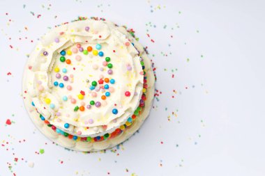 Masanın üstüne renkli şekerlemeler serpiştirilmiş nefis bento keki. Metin için boşluk