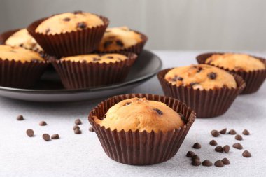 Açık gri masada çikolata parçalı lezzetli kek, yakın plan.