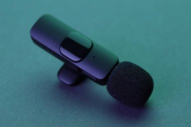 Lavalier mikrofonu karanlık masada, neon ışıklarda, yakın plan.